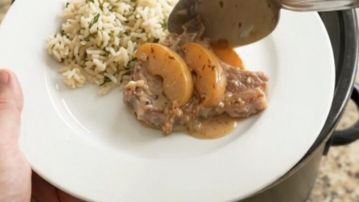 Slow cooker pork chops with creamy apple cider sauce and caramelized apples in a crockpot