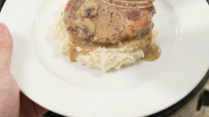 Bone-in pork chops in creamy mushroom-ranch sauce in a black slow cooker
