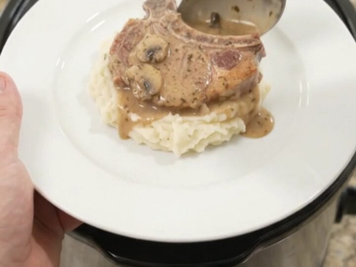 Bone-in pork chops in creamy mushroom-ranch sauce in a black slow cooker
