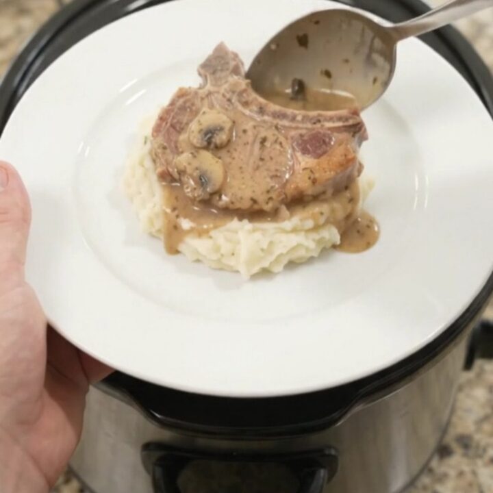 Bone-in pork chops in creamy mushroom-ranch sauce in a black slow cooker