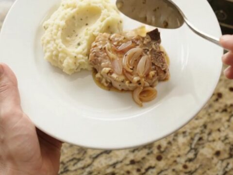 Bone-in pork chops in a bubbling Gruyère cream sauce with honey-Dijon shallots in a slow cooker.