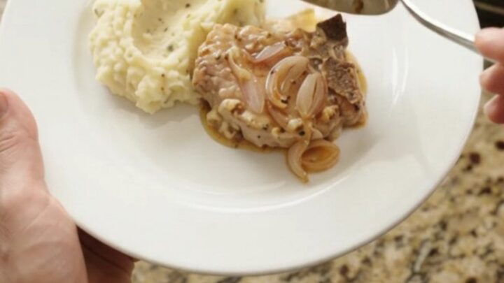 Bone-in pork chops in a bubbling Gruyère cream sauce with honey-Dijon shallots in a slow cooker.