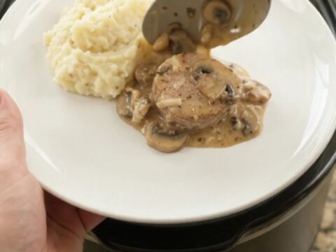 Crockpot filled with creamy Gruyère ranch pork medallions, bubbling and steaming