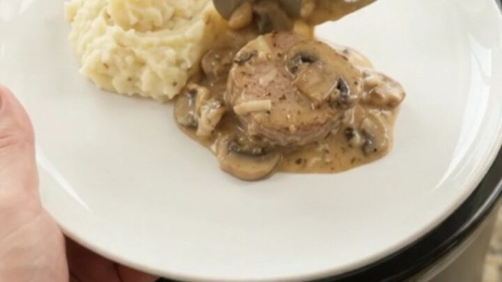 Crockpot filled with creamy Gruyère ranch pork medallions, bubbling and steaming