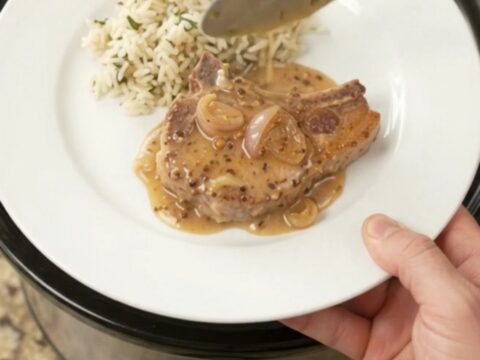 Bone-in ribeye pork chops in a creamy Parmesan honey Dijon sauce in a slow cooker.