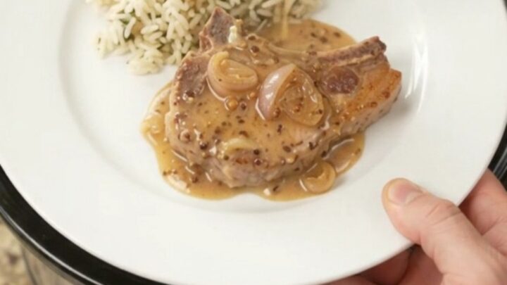 Bone-in ribeye pork chops in a creamy Parmesan honey Dijon sauce in a slow cooker.