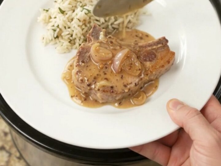 Bone-in ribeye pork chops in a creamy Parmesan honey Dijon sauce in a slow cooker.