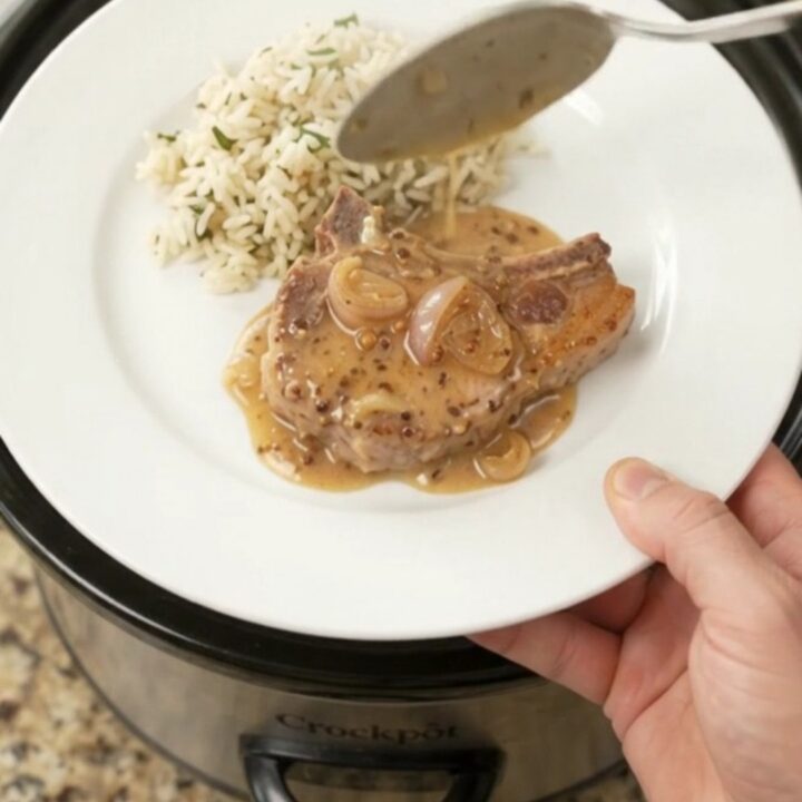Bone-in ribeye pork chops in a creamy Parmesan honey Dijon sauce in a slow cooker.