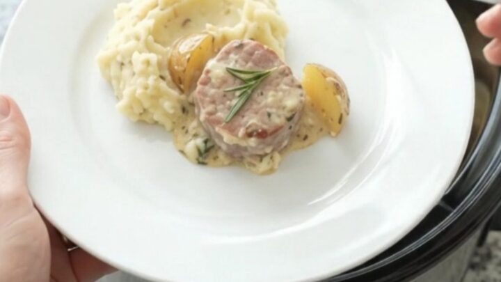 Slow cooker with pork medallions and baby potatoes in creamy Gruyère sauce