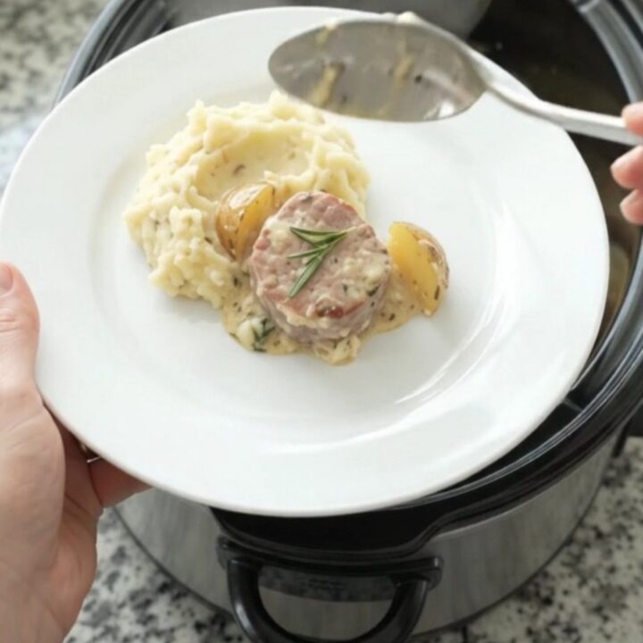 Slow cooker with pork medallions and baby potatoes in creamy Gruyère sauce