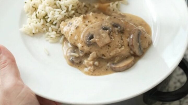 Creamy Parmesan ranch mushroom turkey cutlets in a slow cooker, garnished with fresh herbs, with steam rising.