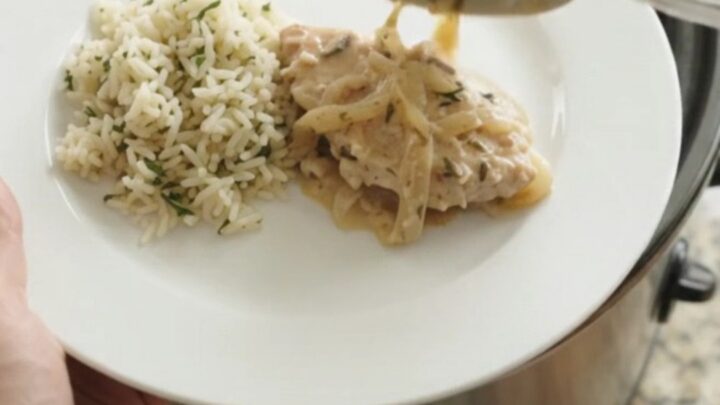 Slow cooker filled with creamy Parmesan French onion turkey cutlets, garnished with thyme