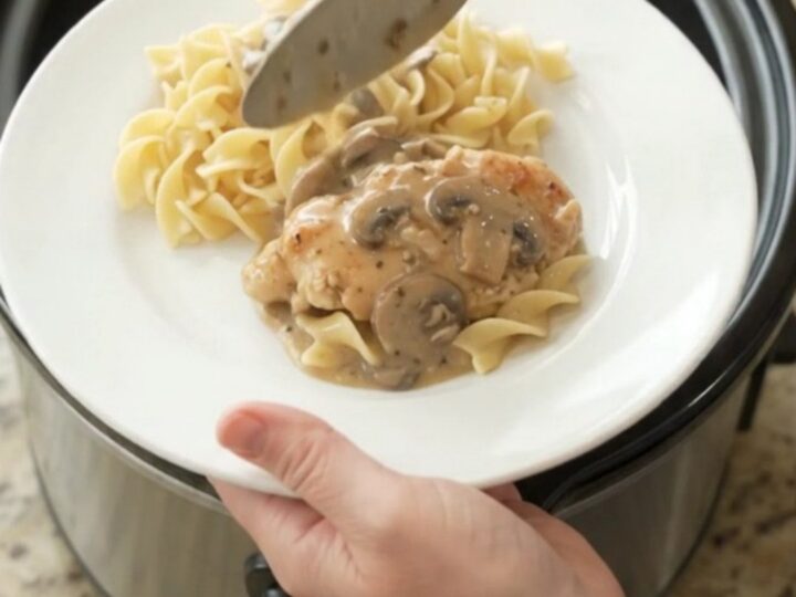 Creamy sour cream ranch mushroom chicken cutlets in a slow cooker with sauce bubbling