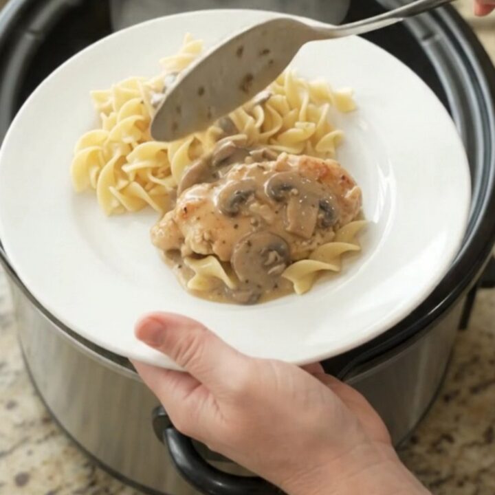Creamy sour cream ranch mushroom chicken cutlets in a slow cooker with sauce bubbling