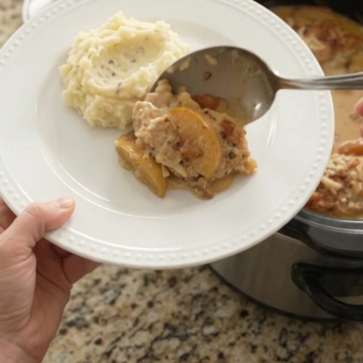 Slow cooker chicken cutlets with apples and Gruyère cream sauce, bubbling in the crockpot