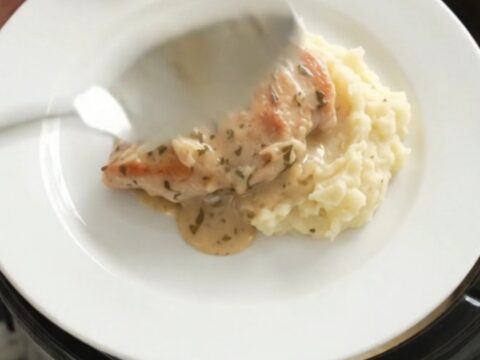 Slow cooker turkey cutlets and baby potatoes in a creamy Gruyère sauce, garnished with rosemary.