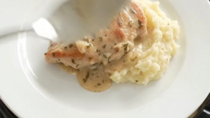 Slow cooker turkey cutlets and baby potatoes in a creamy Gruyère sauce, garnished with rosemary.