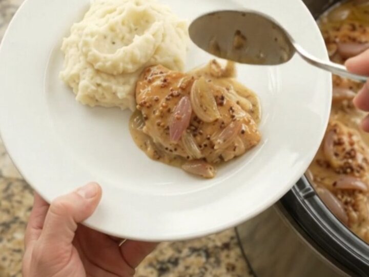 Slow-cooker honey Dijon chicken cutlets in a creamy sauce with shallots, in a black crock