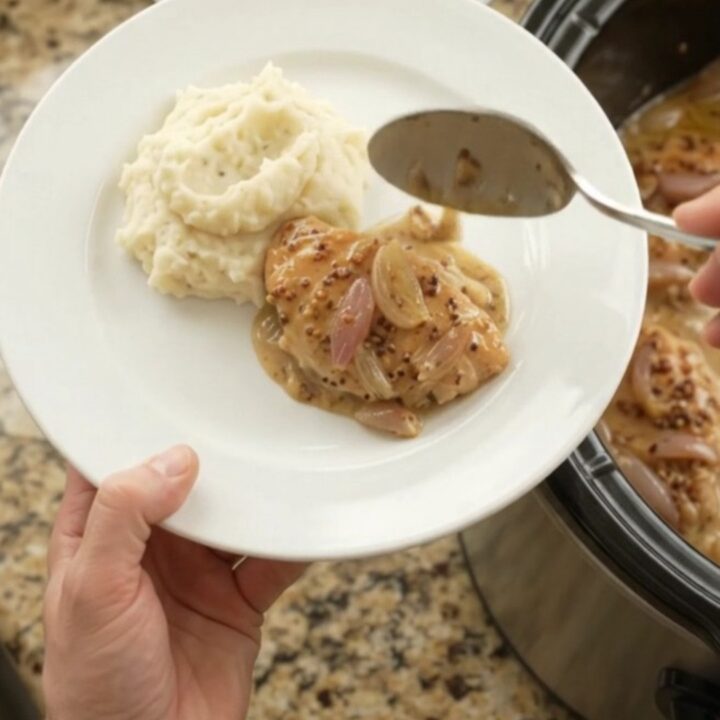 Slow-cooker honey Dijon chicken cutlets in a creamy sauce with shallots, in a black crock