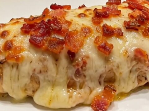 A close-up of a perfectly cooked bacon ranch mozzarella chicken breast with melted cheese and crispy bacon.