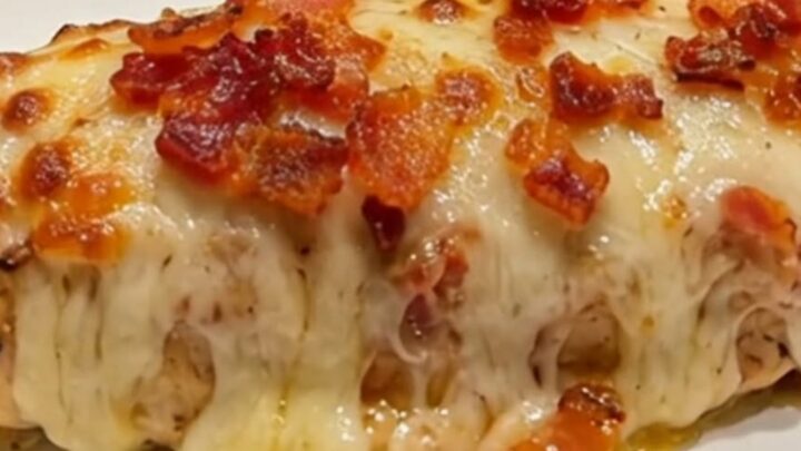 A close-up of a perfectly cooked bacon ranch mozzarella chicken breast with melted cheese and crispy bacon.