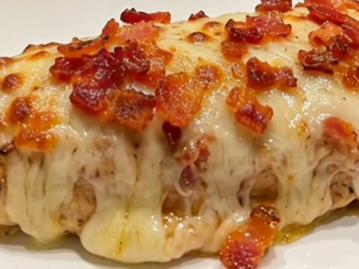 A close-up of a perfectly cooked bacon ranch mozzarella chicken breast with melted cheese and crispy bacon.