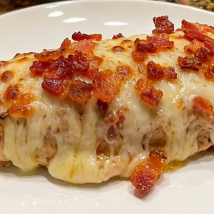 A close-up of a perfectly cooked bacon ranch mozzarella chicken breast with melted cheese and crispy bacon.