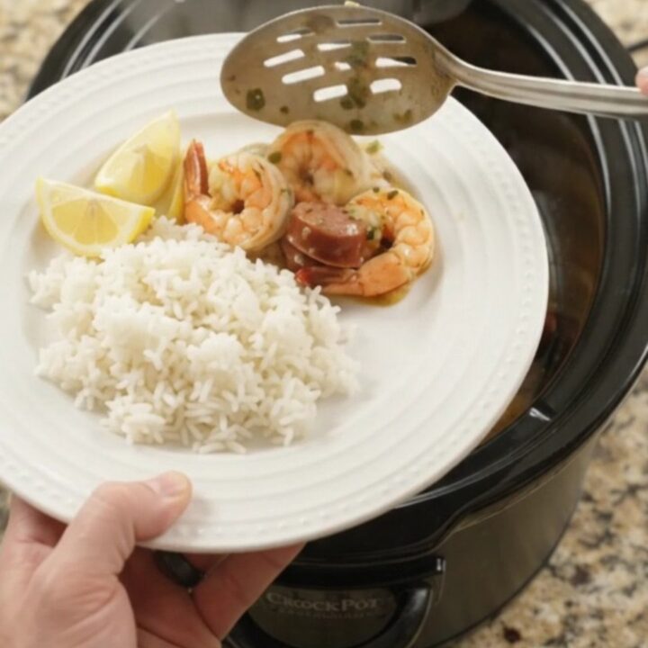 Slow cooker filled with chili lime butter shrimp, sausage, and potatoes