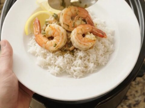Snow crab, shrimp, corn, and potatoes in a slow cooker with butter sauce.