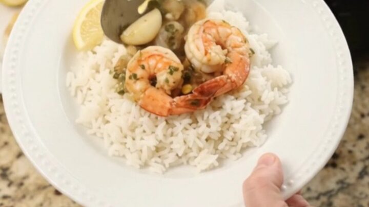 Slow cooker filled with snow crab, shrimp, corn, and garlic in a golden butter sauce