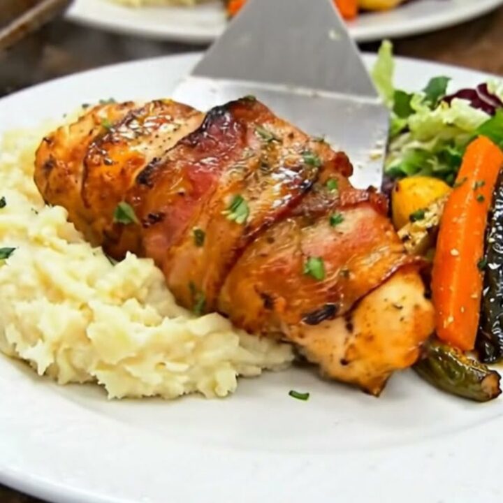 A golden honey-glazed bacon-wrapped chicken breast served over creamy mashed potatoes.