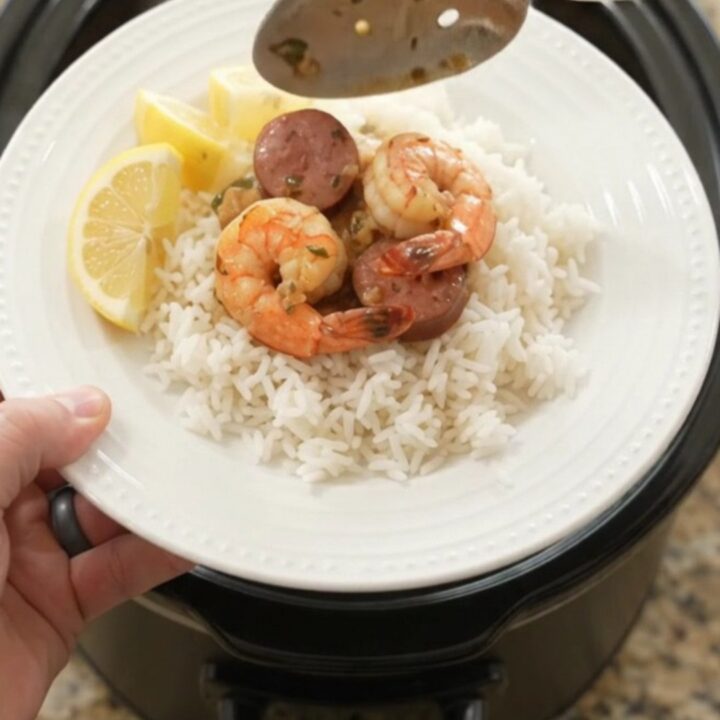 Slow cooker filled with snow crab, shrimp, and sausage in chili-lime butter