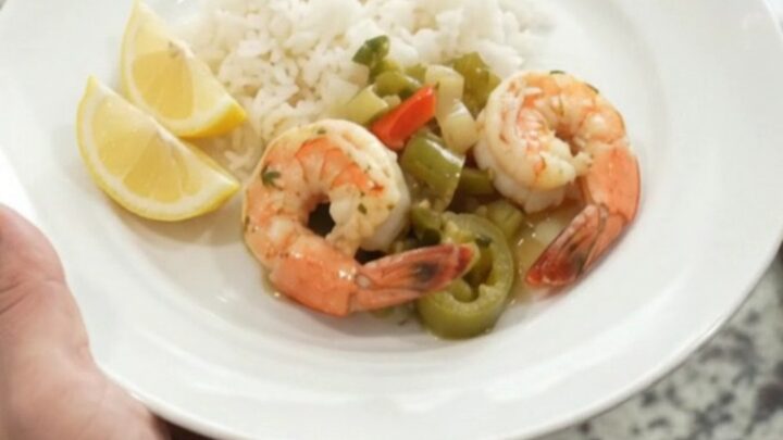 Crockpot full of snow crab and shrimp in golden butter sauce with peppers and onions