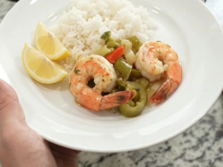 Crockpot full of snow crab and shrimp in golden butter sauce with peppers and onions