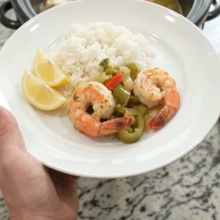 Crockpot full of snow crab and shrimp in golden butter sauce with peppers and onions