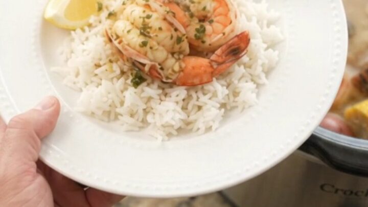 Slow-cooker seafood boil with lobster tails, shrimp, corn, and potatoes in a garlic butter sauce.