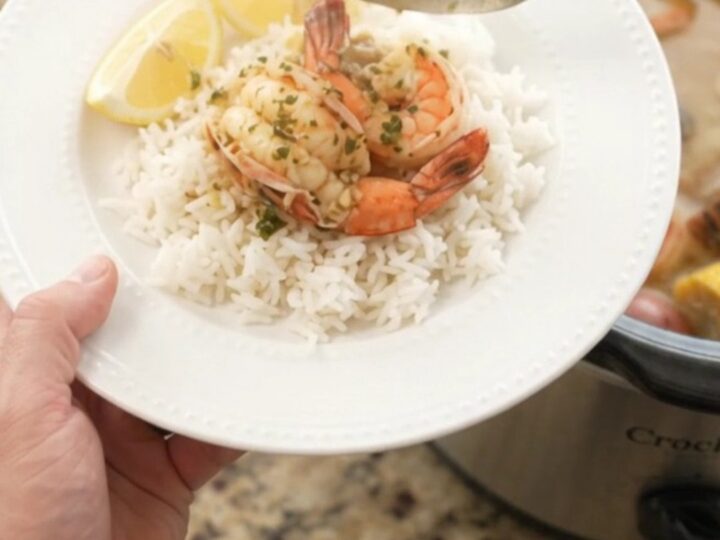 Slow-cooker seafood boil with lobster tails, shrimp, corn, and potatoes in a garlic butter sauce.