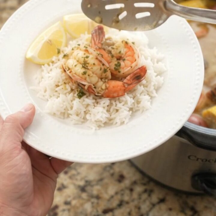 Slow-cooker seafood boil with lobster tails, shrimp, corn, and potatoes in a garlic butter sauce.
