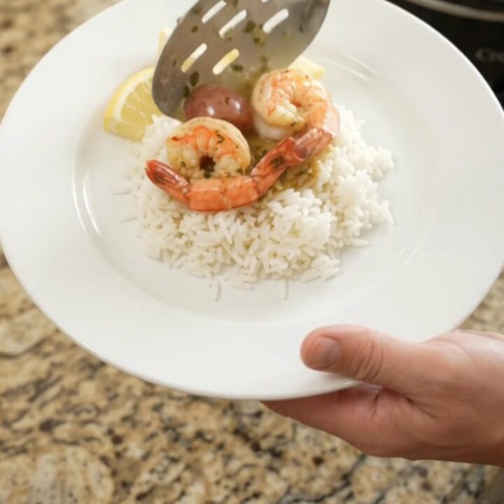 Crockpot herb butter cajun boil with lobster tails, shrimp, corn, and potatoes in a slow cooker.