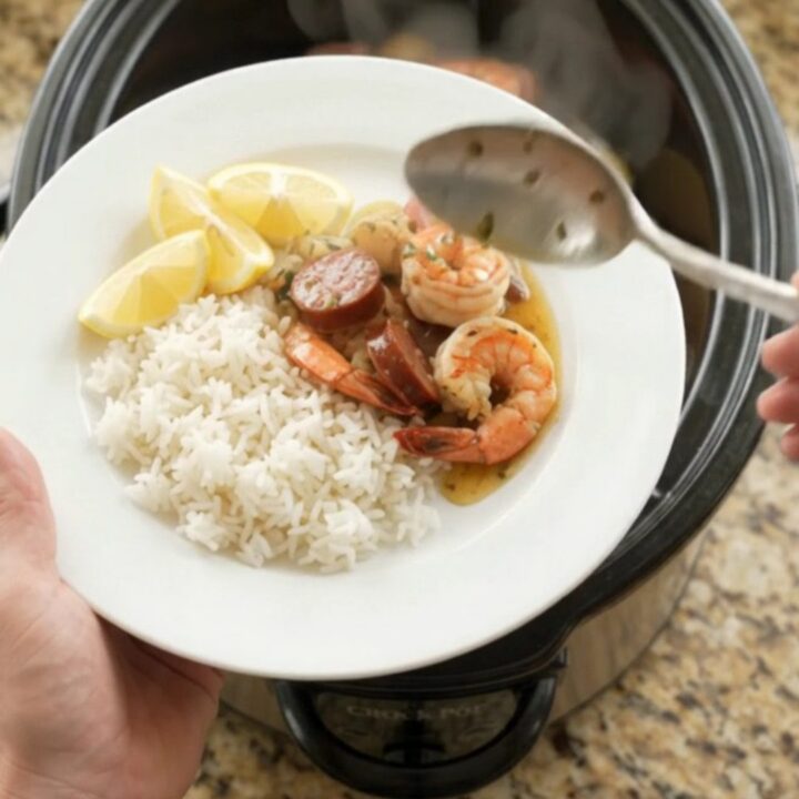 Slow cooker seafood boil with lobster tails, shrimp, sausage, and potatoes in a buttery Old Bay sauce