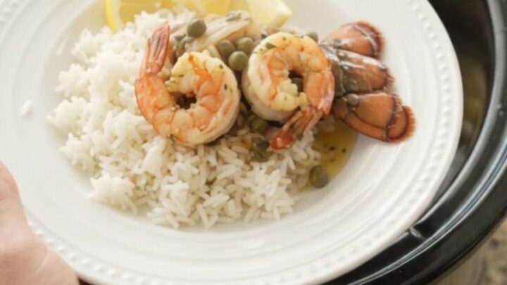 Slow cooker lobster tails and shrimp in a golden butter sauce with lemon slices and capers.