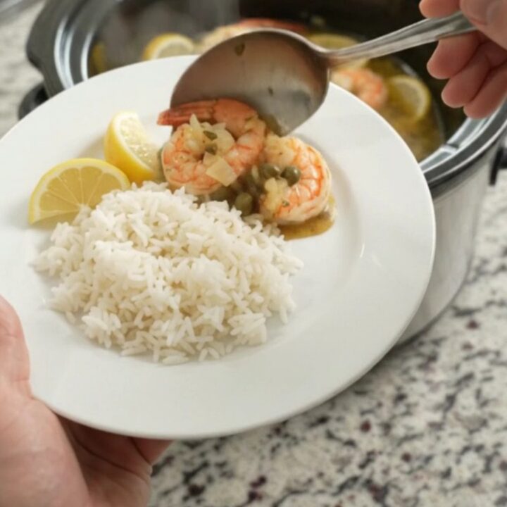 Slow cooker lobster tails and shrimp in golden Old Bay butter with lemon slices and capers