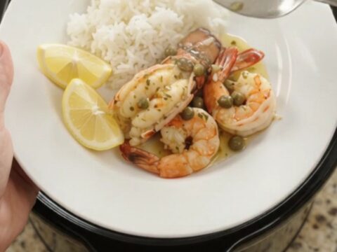 Slow cooker chili lime lobster tails and shrimp in a glossy butter sauce with lemon slices and capers.