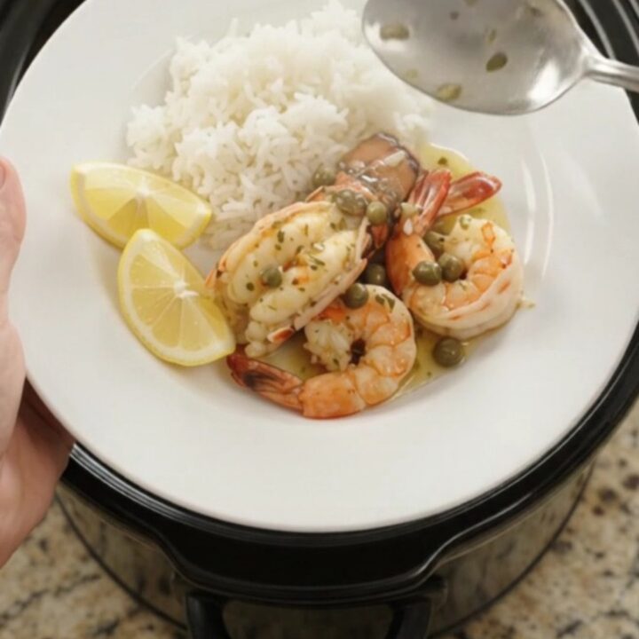 Slow cooker chili lime lobster tails and shrimp in a glossy butter sauce with lemon slices and capers.