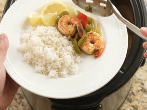 Slow cooker chili lime butter lobster tails and shrimp with bell peppers and onions, glistening in a buttery sauce.