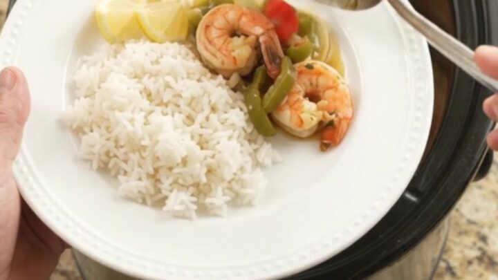 Slow cooker chili lime butter lobster tails and shrimp with bell peppers and onions, glistening in a buttery sauce.