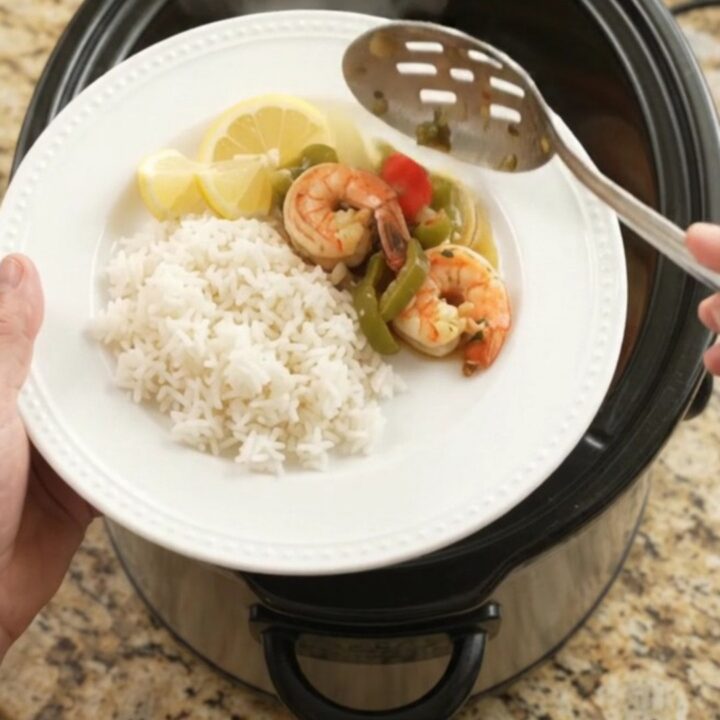 Slow cooker chili lime butter lobster tails and shrimp with bell peppers and onions, glistening in a buttery sauce.