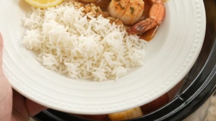 Slow cooker bayou butter Cajun boil with scallops, shrimp, corn, and potatoes in a rich red sauce.
