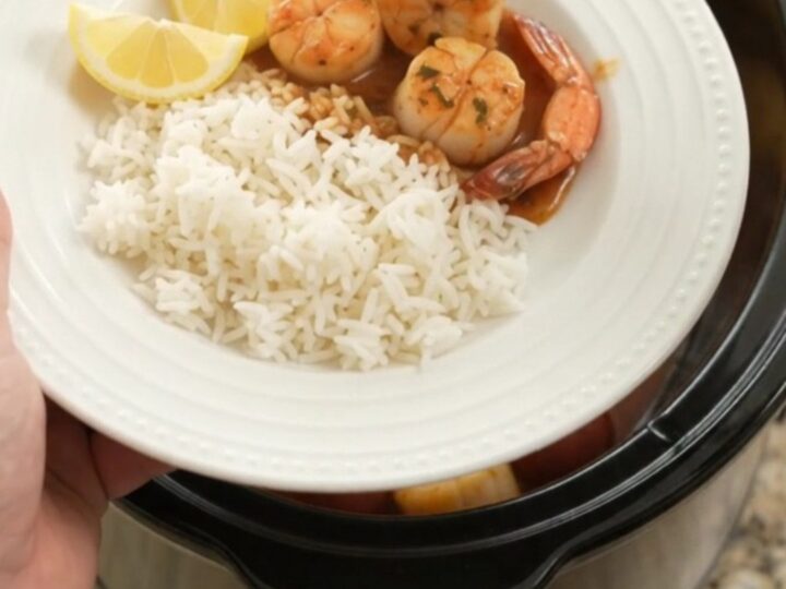 Slow cooker bayou butter Cajun boil with scallops, shrimp, corn, and potatoes in a rich red sauce.