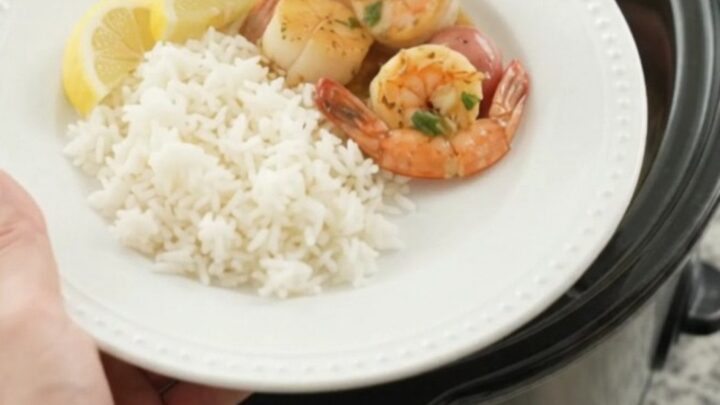 Crockpot chili lime butter seafood boil with scallops, shrimp, corn, and potatoes in a glossy sauce